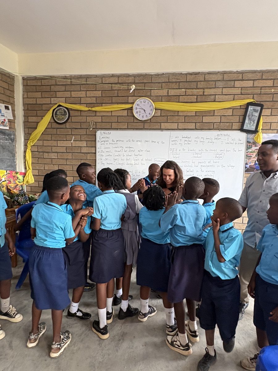 Students gathered around Ellen, smiling and celebrating, at Bright School, a village school near Muhanga, Rwanda